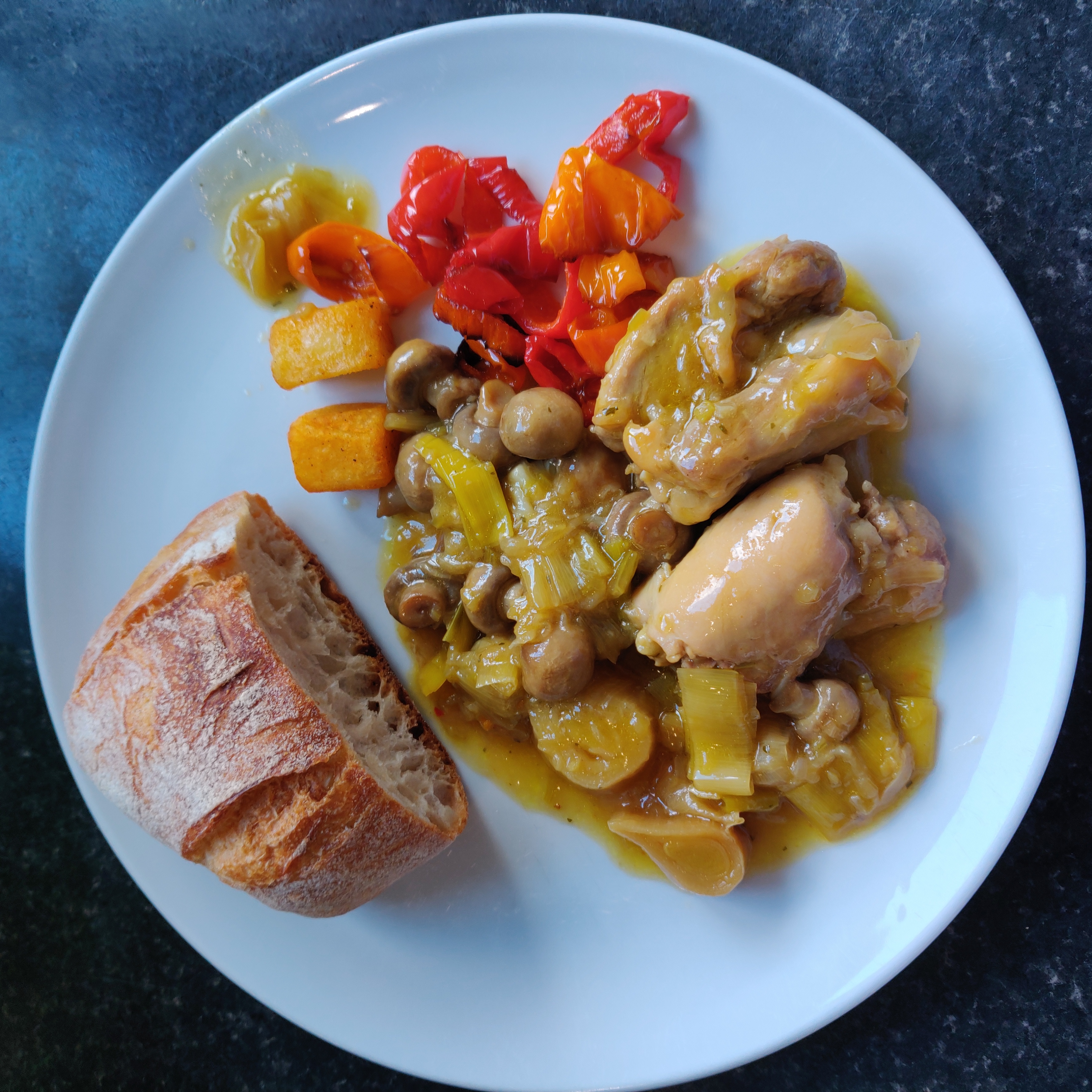 Chicken with leeks and mushrooms, served with fried peppers and crusty bread